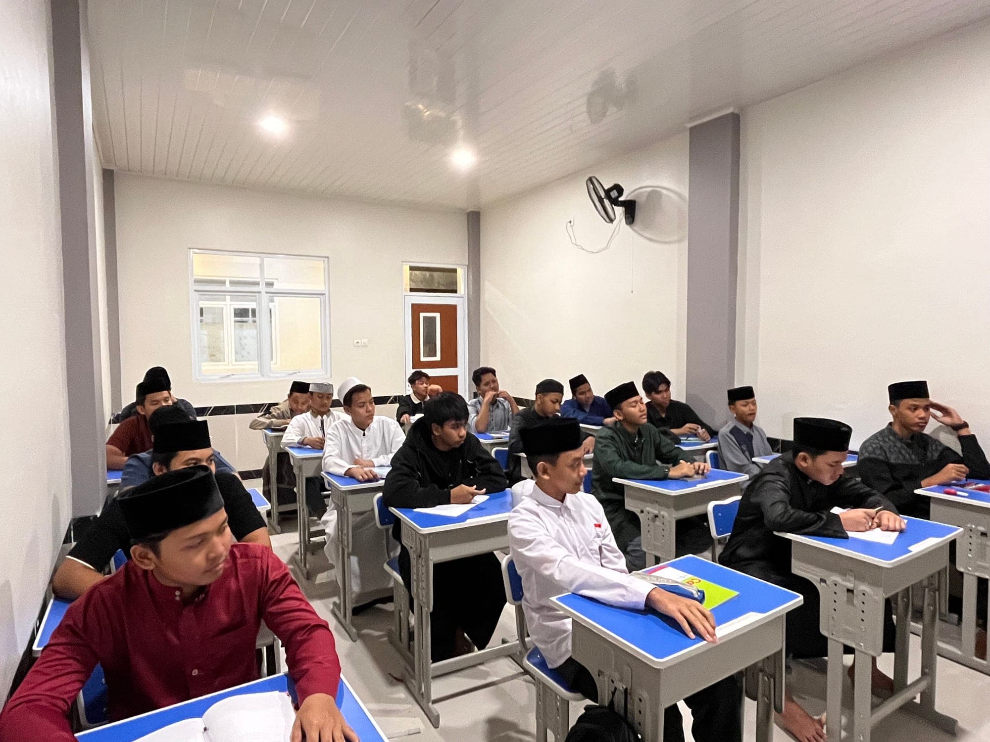 Santri MTs dan MA Wadi Mubarak menyimak pelajaran di ruang kelas pada jam belajar malam