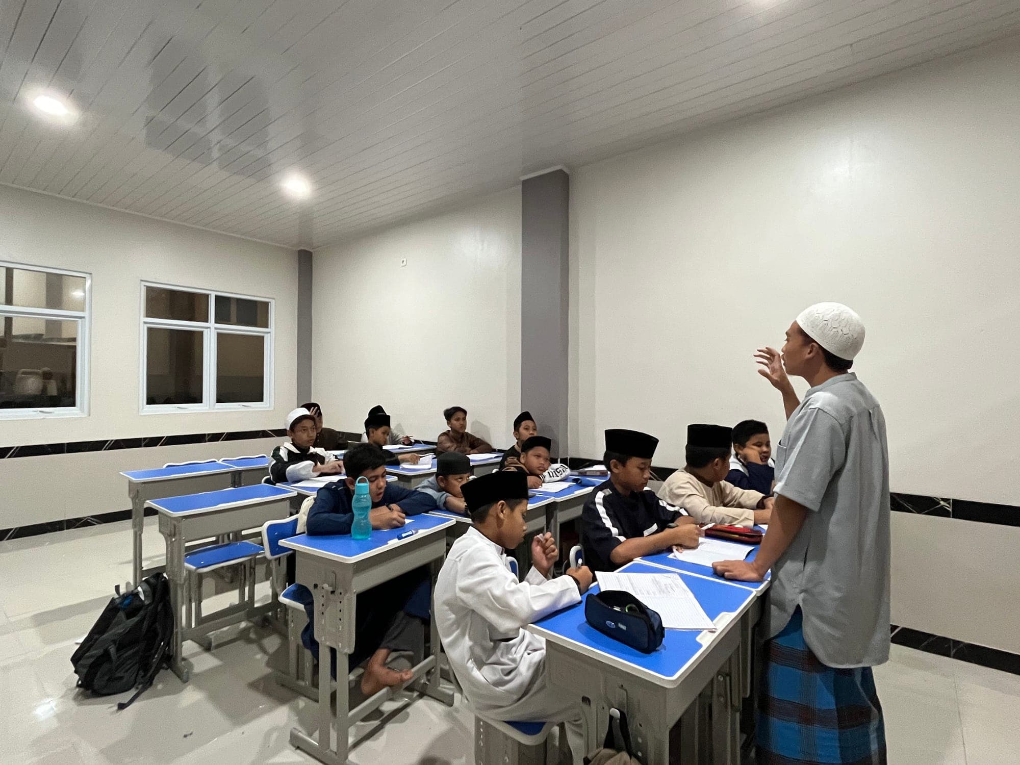 Ustadz menjelaskan pelajaran kepada santri MTs dan MA Wadi Mubarak pada jam belajar malam