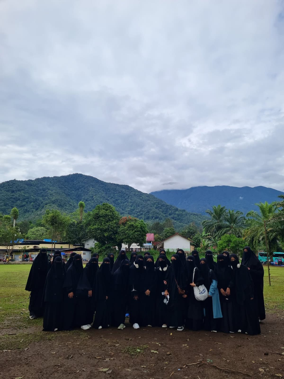 Peserta PG TAUD SAQU berfoto bersama saat rihlah di lapangan berlatar pegunungan